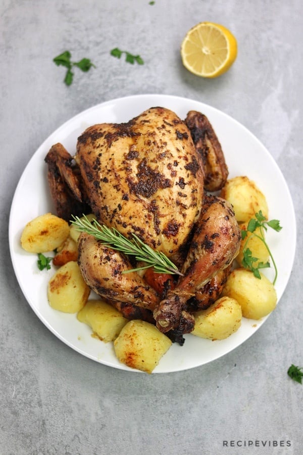 simple roast chicken served with roast potatoes and garnished with rosemary