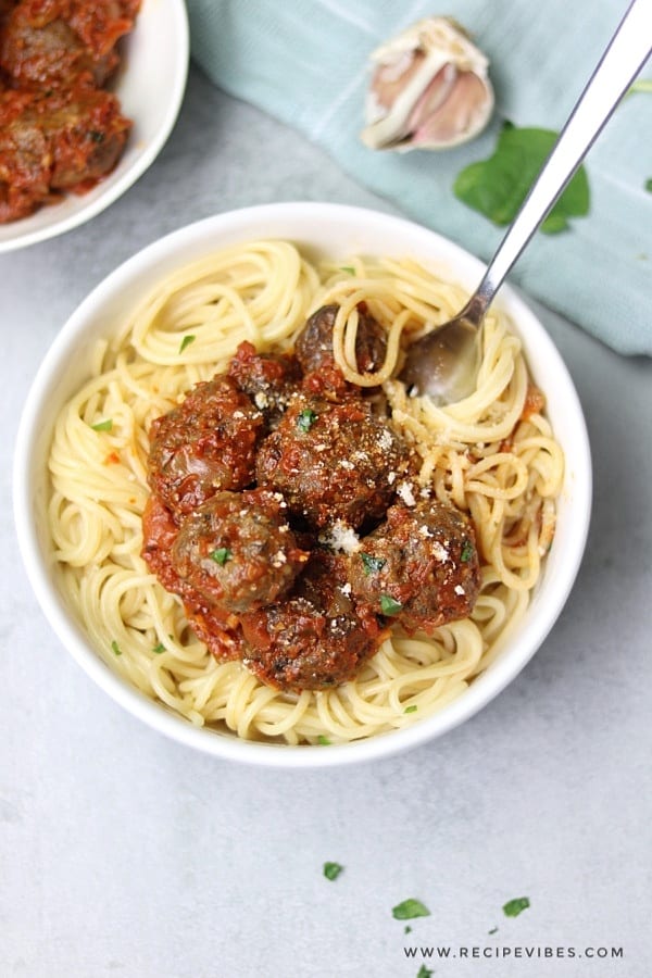parmesan sprinkled on spaghetti and meatballs sauce