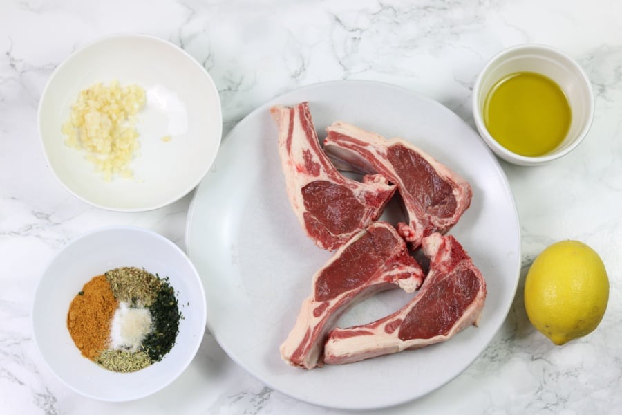 ingredients for instant pot pressure cooker lamb chops including lemon, garlic, rosemary set out on a board