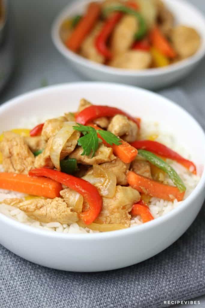 instant pot chicken stir fry served on rice in a white plate