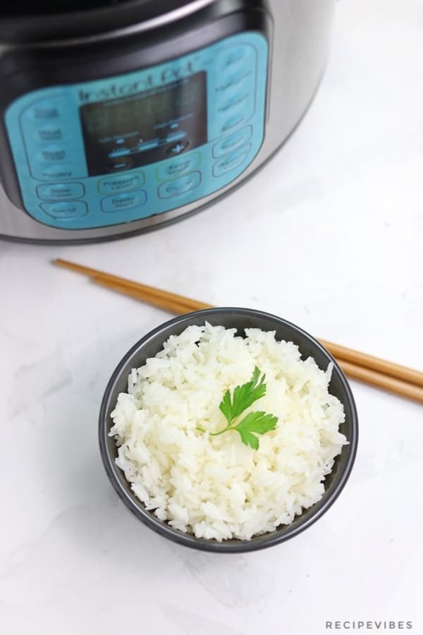 instant pot jasmine rice served in black bowl  with chopsticks by the side