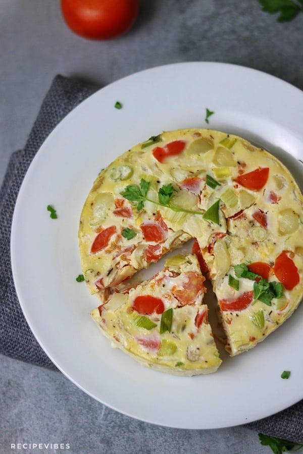 Instant pot omelette on white plate with a piece cut out