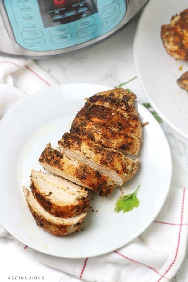 Sliced Instant pot chicken breast on white place.