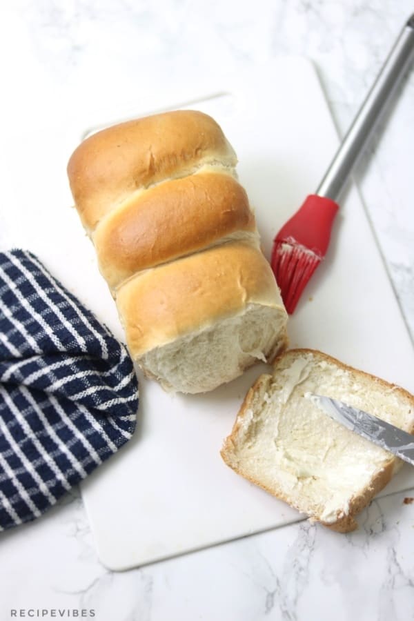 Featuring a slice from the loaf with butter spread on