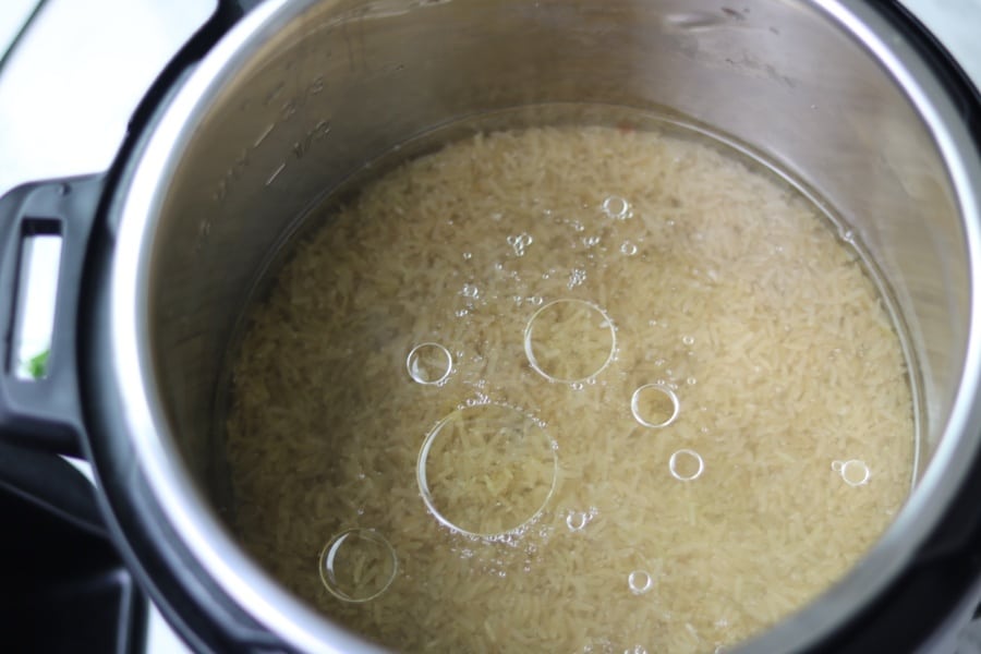 picture showing process of cooking . rice, water and oil added in instant pot