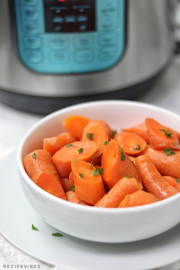 steamed carrots bowl placed in front of pressure cooker