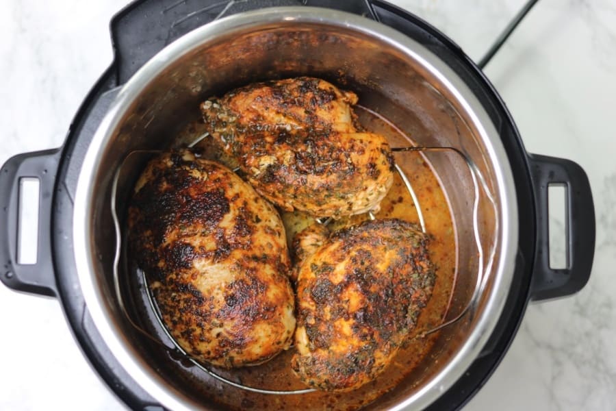 browned chicken breasts on trivet inside instant pot.