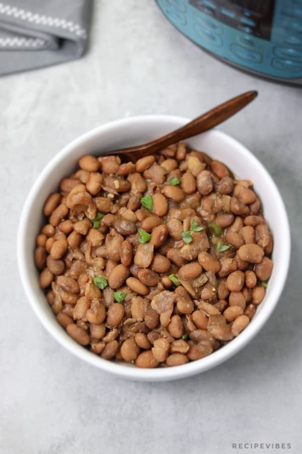 cooked pinto beans served in white bowl