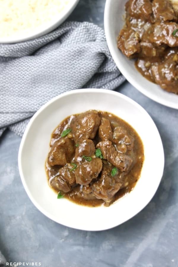 Beef tips and gravy served in small white bowl