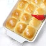 Bread rolls inside oven dish brushed with butter