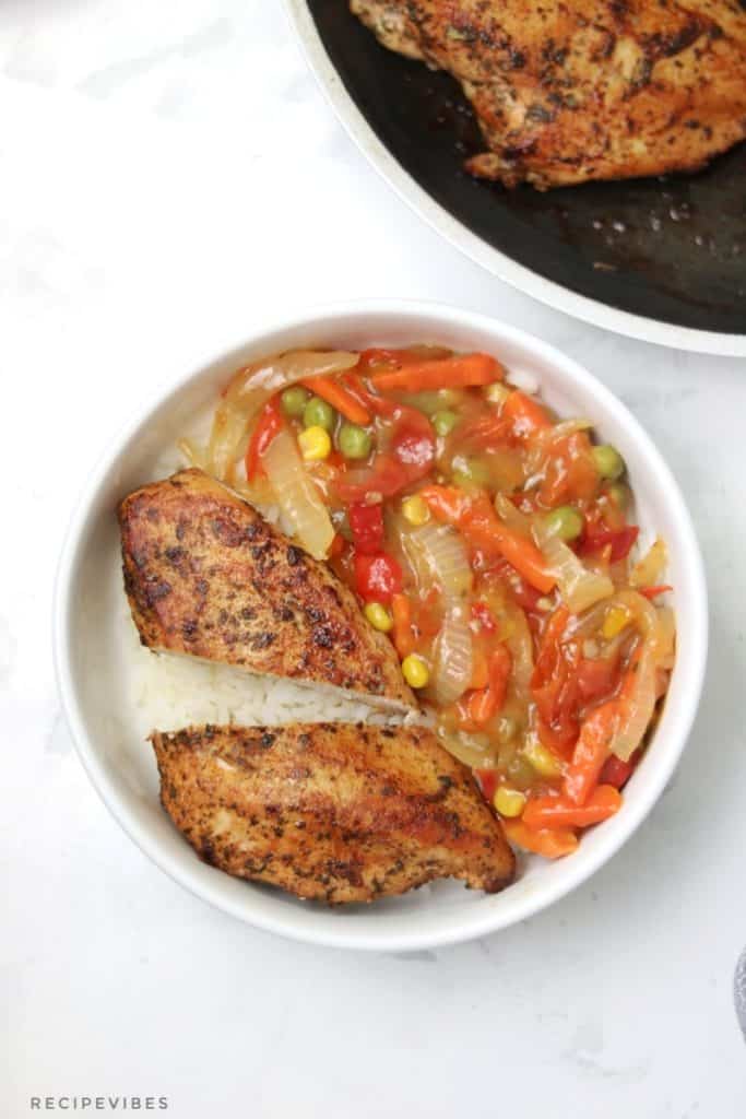 pan seared chicken breast served on rice with vegetables