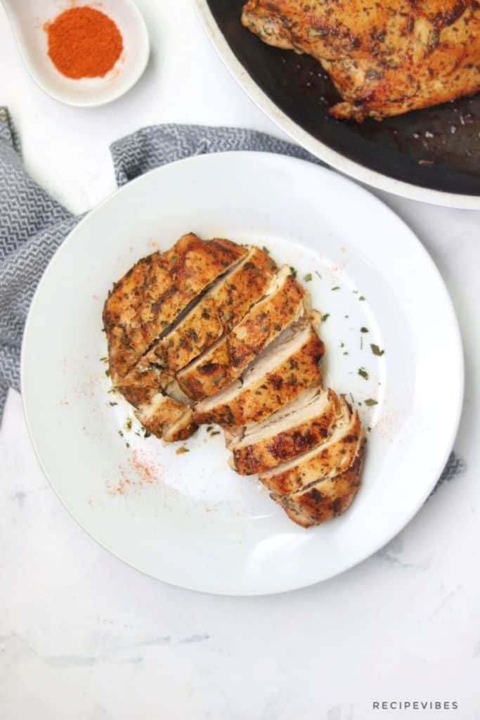 stovetop chicken breast sliced up on a plate and sprinkled with paprika