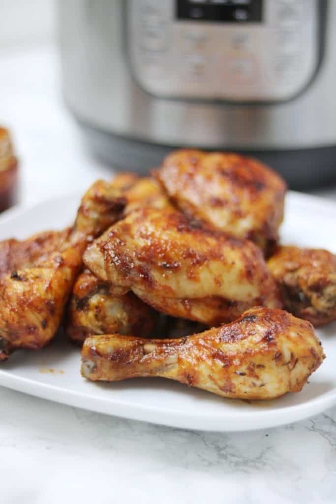 bbq chicken legs displayed in front of instant pot