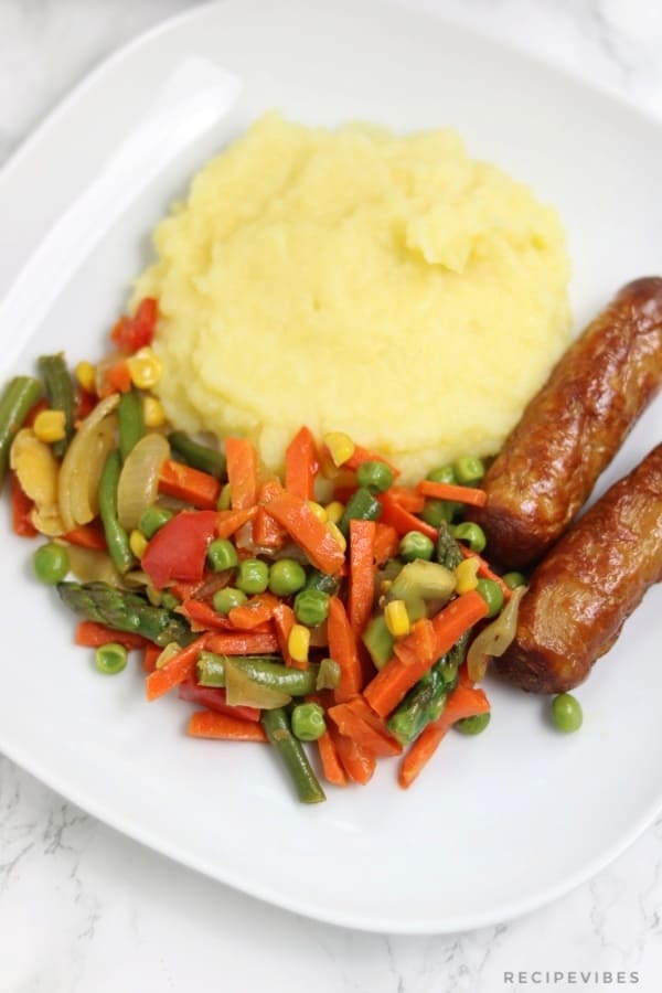 Sauteed vegetables served with mashed potatoes and sausages