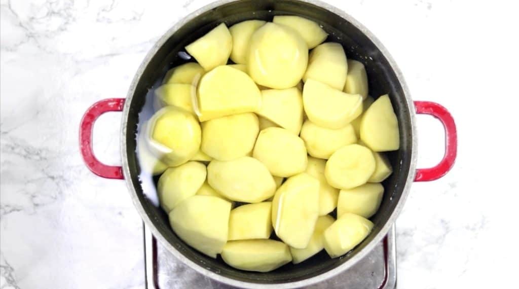 cut up rinsed potatoes inside pot coand covered with water