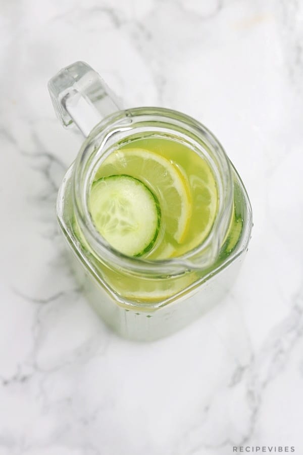 cucumber juice in a pitcher with lemon and cucumber slices inside.