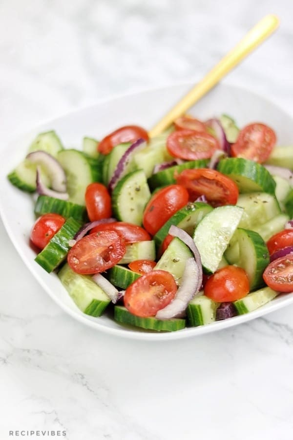 cucumber tomato salad served on white plate