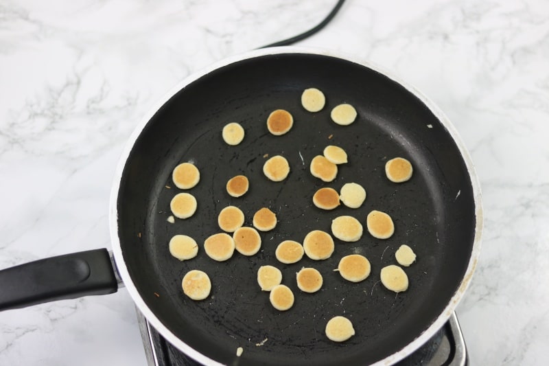 mini pancakes turned over inside the non stick pan to cook the other side.