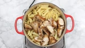 pasta and chicken added into the pot of bell peppers and cream