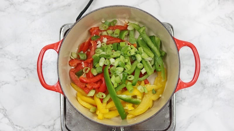 oil, bell peppers, spring onions,garlic added in a pot to saute.