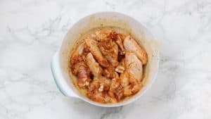 marinated chicken wings in a white bowl.