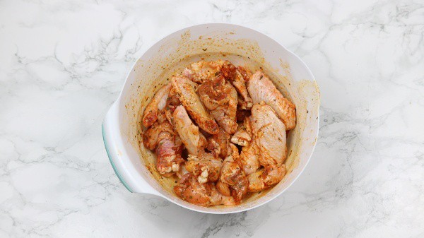 marinated wings in a white bowl.