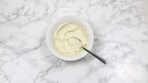 cream cheese, butter, black pepper and parsley mixed in a bowl.