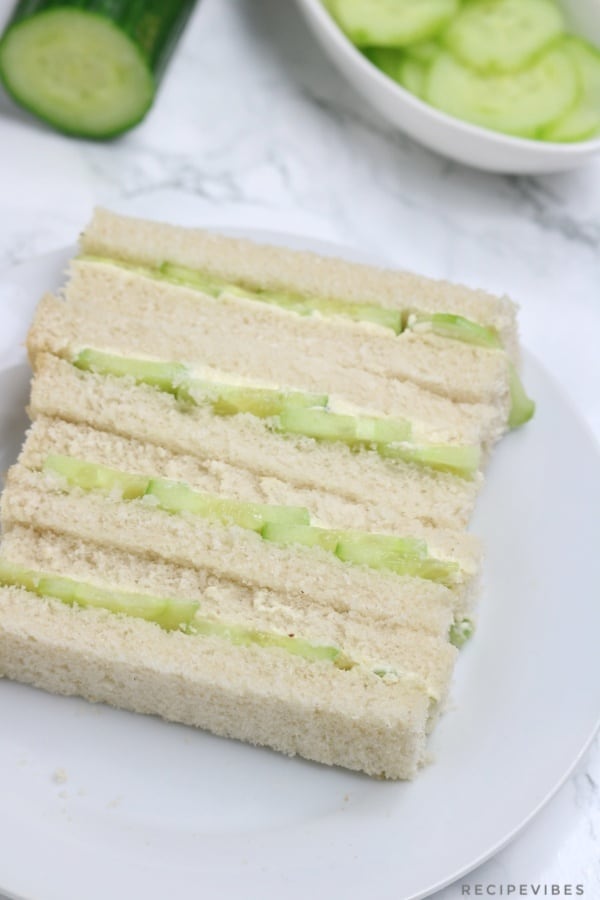4 fingers of cucumber sandwiches on a plate.