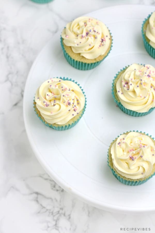 4 cupcakes with vanilla buttercream and sprinkles.