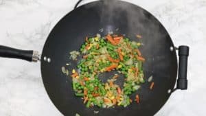 onions, garlic and mixed vegetables in a wok.