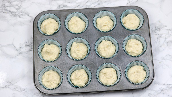 cake batter put in 12 blue cupcake cases in muffin pan
