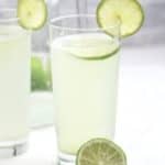Lime juice in a glass cup garnished with a slice of lime.