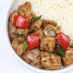 A plate of black pepper chicken served on white rice.