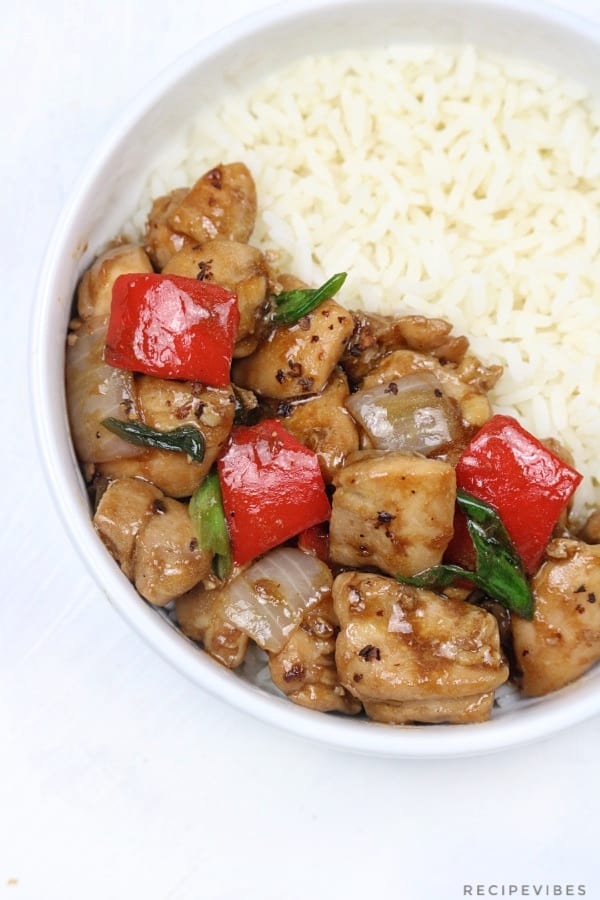 A plate of black pepper chicken served on white rice.