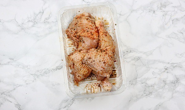marinated chicken in a plastic bowl.