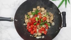 vegetables added into the wok of sauted chicken.