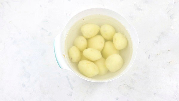peeled potatoes in a bowl of water.