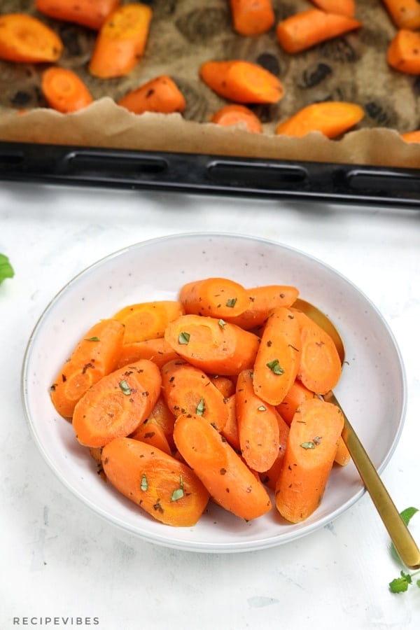 roasted carrots in a plate and in oven tray.