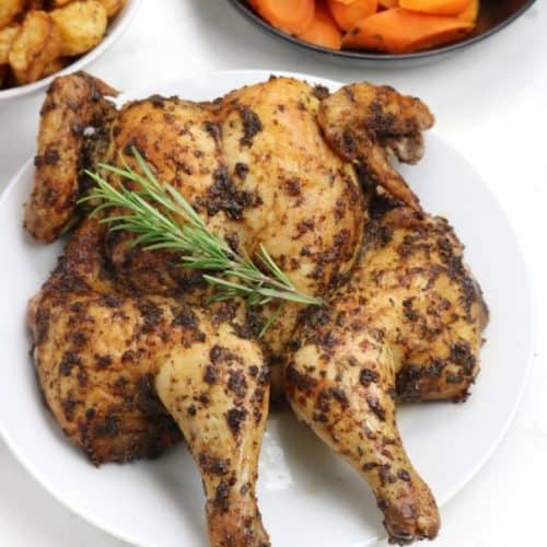 spatchcock chine, roasted carrots and roasted potatoes displayed.