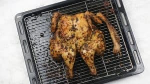 roasted spatchcock chicken on oven tray.