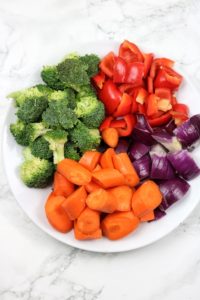 cut veggies in a white flat plate.