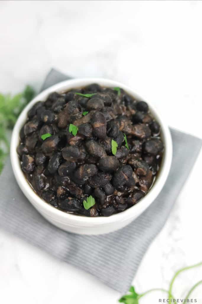 cooked black beans in white ramekin.