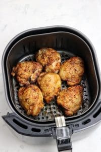 air fried chicken thighs in fryer basket.