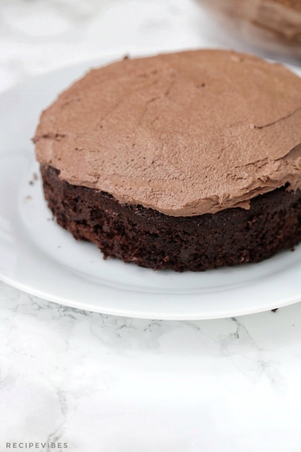 chocolate buttercream frosting spread on chocolate cake.