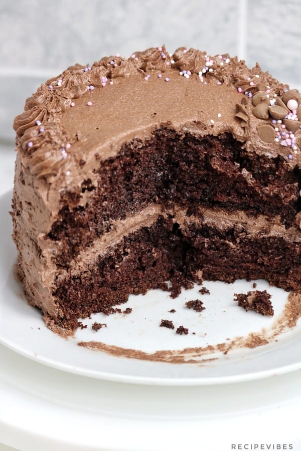 frosted round chocolate cake with a portion cut out.