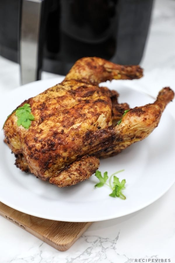 whole roast chicken served on white plate.