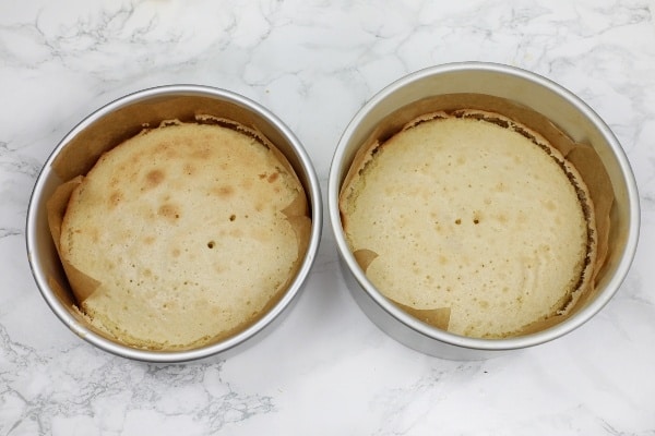 2 Baked cakes in cake pans.