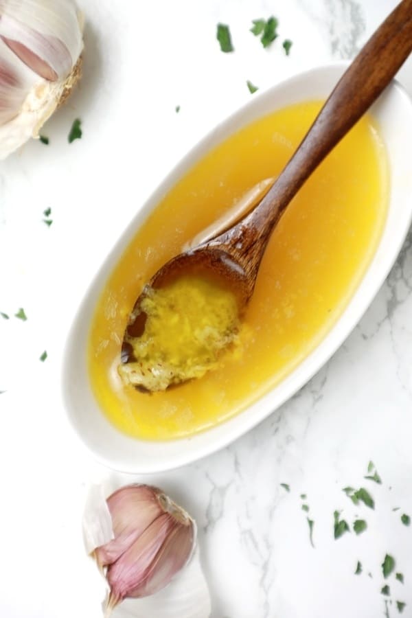 garlic butter sauce for steak, pizza, fish, and more shown in a bowl.