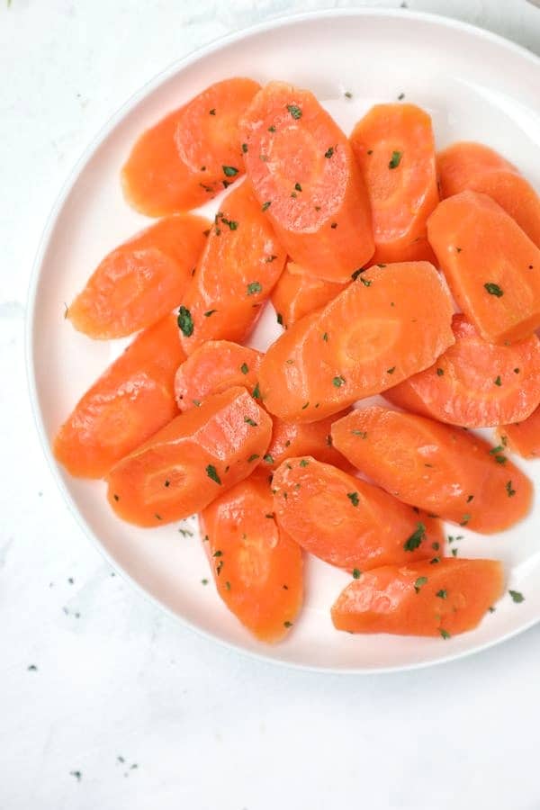 boiled carrots served in a white plate.
