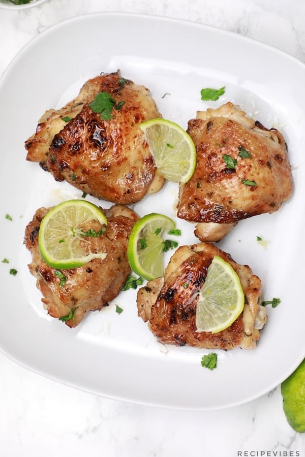 Lime chicken served on a plate and garnished with lime slices.